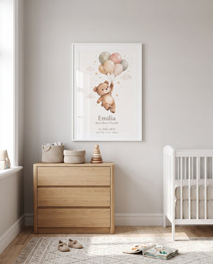 Bärenposter mit Luftballons im weißen Rahmen über einer Holzkommode im Babyzimmer, daneben ein weißes Gitterbett; Körbe und Stapelspielzeug stehen auf der Kommode.