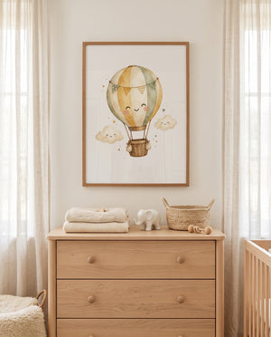 Kinderzimmer-Poster mit Heißluftballon über einer Holzkommode im Babyzimmer