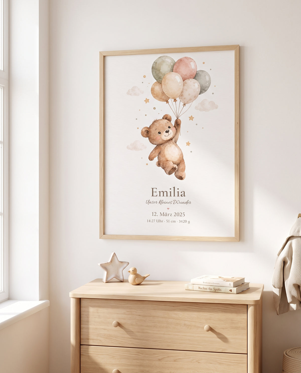Poster mit einem schwebenden Bären und pastellfarbenen Luftballons im Holzrahmen über einer Holzkommode mit Sternfigur, kleiner Holzente und Büchern neben einem Fenster.