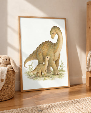 Dino-Duo-Poster im hellen Holzrahmen, auf dem Holzboden an die Wand gelehnt. Links steht ein geflochtener Korb mit Plüschhase und Decke, rechts ist ein Holzmöbel mit gemustertem Stoff sichtbar; im Vordergrund liegt ein heller Teppich.