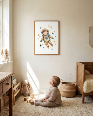 Gerahmtes Astronautenposter an einer hellen Wand im Kinderzimmer. Ein Kleinkind sitzt mit Holzbausteinen auf einem flauschigen Teppich, umgeben von Stoffhasen, einem Korb und Holzmöbeln.