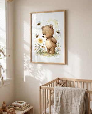 Gerahmtes Bär-und-Bienen-Poster über einem Holz-Gitterbett mit Stoffteddy und über dem Gitter hängendem Tuch; links ein Fenster und ein niedriger Tisch mit Büchern und Holzspielzeug.