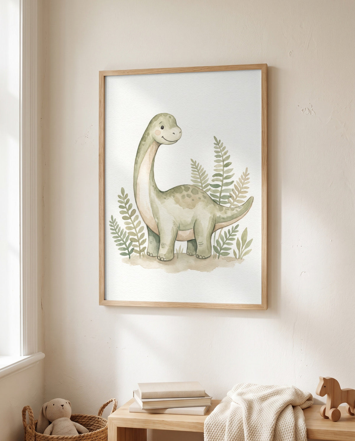 Gerahmtes Langhals-Dino-Poster neben einem Fenster über einer Holzbank mit Büchern, heller Strickdecke und Holzpferd; daneben ein Korb mit Stofftier.