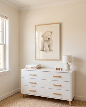 Poster mit hellem Eisbär-Motiv in einem minimalistisch eingerichteten Babyzimmer