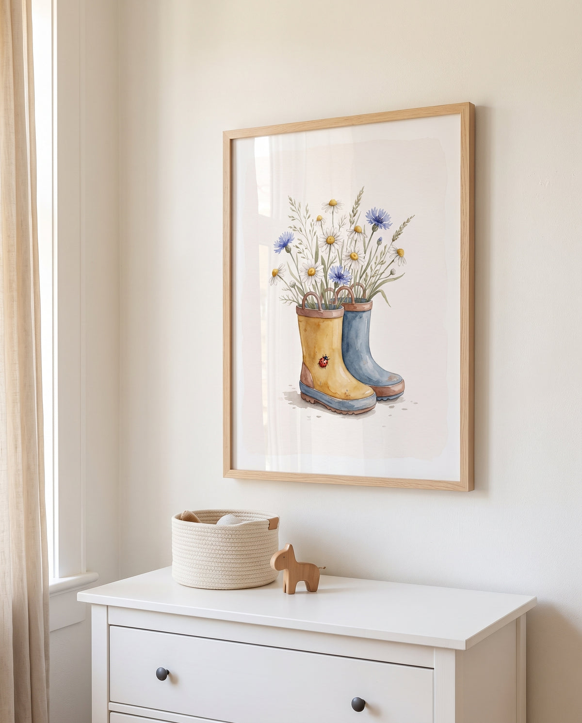 Wiesenblumen-Motiv in zwei Kinderstiefeln im Holzrahmen über einer weißen Kommode mit Korb und Holzfigur